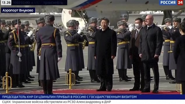 Le président chinois Xi Jinping se tient debout lors d'une cérémonie officielle de bienvenue à son arrivée à l'aéroport gouvernemental à Moscou.