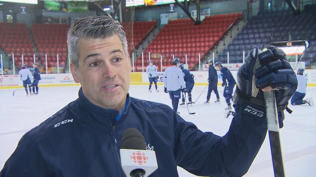 L'entraîneur-chef des Saguenéens de Chicoutimi, Yanick Jean, accorde une entrevue à une équipe de Radio-Canada. 