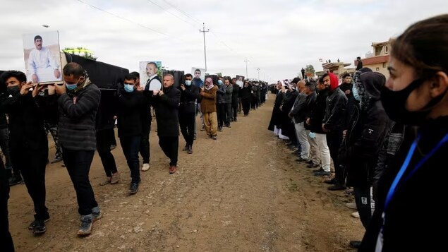 Mourners carry the remains of Yazidi victims of ISIS following their exhumation from a mass grave near Kojo, Iraq on February 6, 2021. 