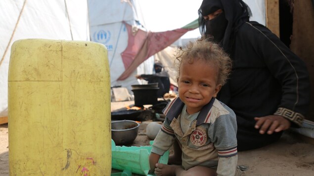 Un jeune enfant pleure assis par terre.