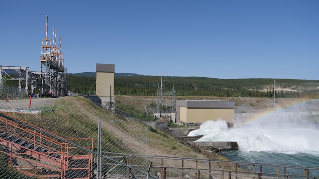Un arc-en-ciel se forme dans l'eau qui s'échappe du barrage hydroélectrique de Whitehorse.