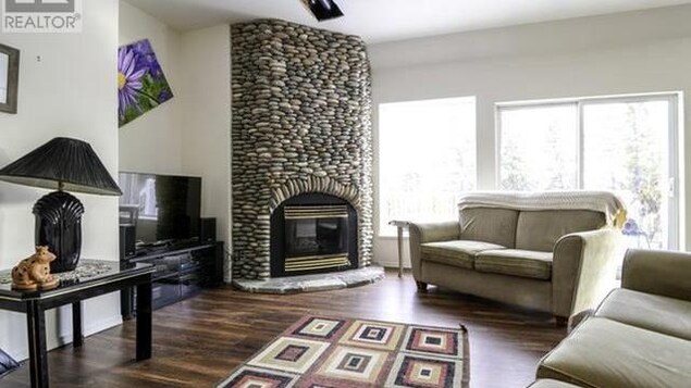 Un salon avec une cheminée en pierres.