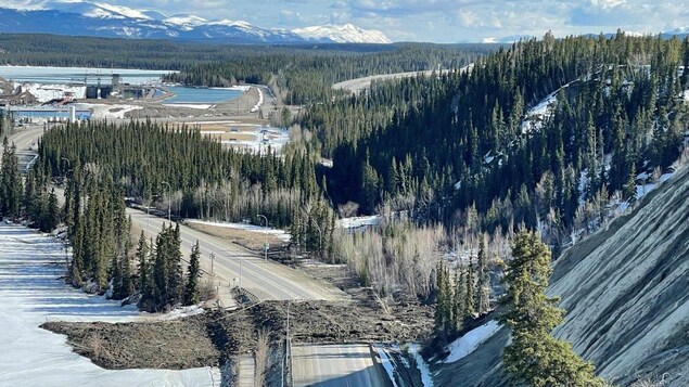 Photo aérienne du glissement de terrain. Des débris recouvrent la chaussée, un sentier et le bord du fleuve toujours gelé.