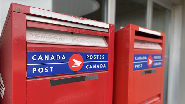 Gros plan sur deux boîtes aux lettres de Postes Canada.