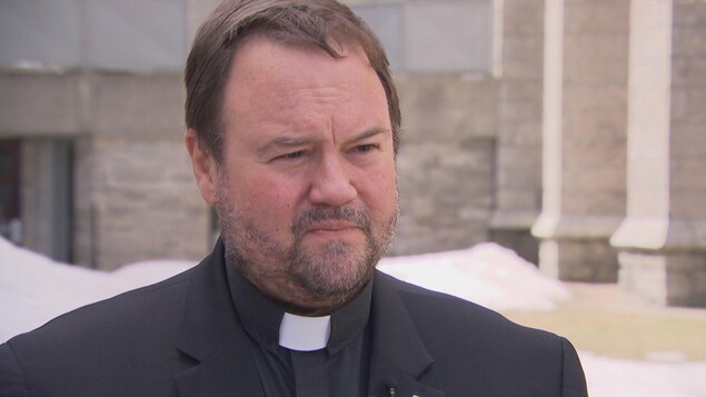 Un homme donne une entrevue devant une église. Un homme donne une entrevue devant une église.