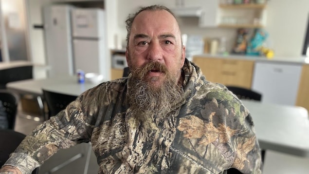 Yves est assis sur une chaise dans la salle à manger de la Maison du Compagnon.