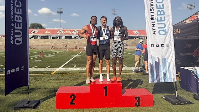 Ils posent avec les médaillés d'argent et de bronze sur la plus haute marche du podium. 