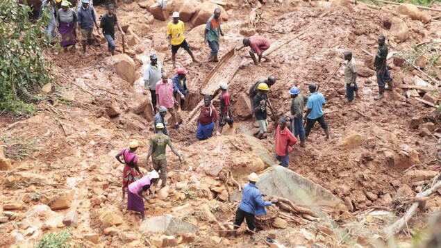 Une famille creuse le sol pour retrouver un fils enseveli sous la boue à Chimanimani à quelque 600 kilometres d'Harare, Zimbabwe