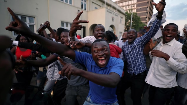 Des Zimbabwéens dans la rue affichent de larges sourires. Des Zimbabwéens dans la rue affichent de larges sourires.
