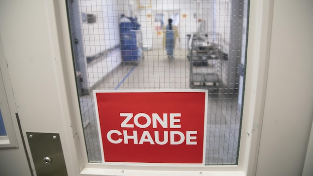 Une affiche collée à une porte où il est écrit : zone chaude.