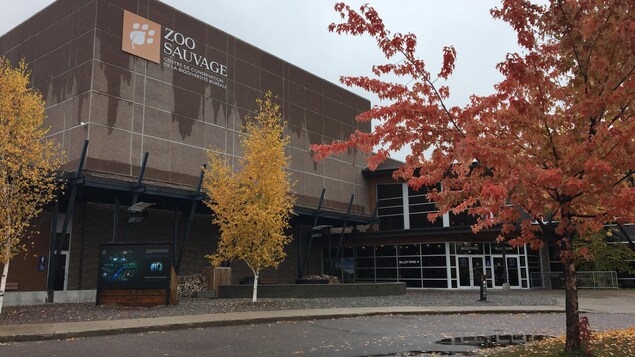 Le bâtiment en pierre et en bois affiche le logo du zoo.