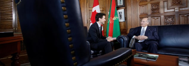 Les deux hommes sont assis de biais sur de magnifiques divans dans un bâtiment du parlement canadien, Les deux hommes sont assis de biais sur de magnifiques divans dans un bâtiment du parlement canadien,