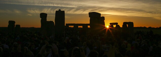 Des gens photographient le soleil qui se lève sur le site Stonehenge. Des gens photographient le soleil qui se lève sur le site Stonehenge.