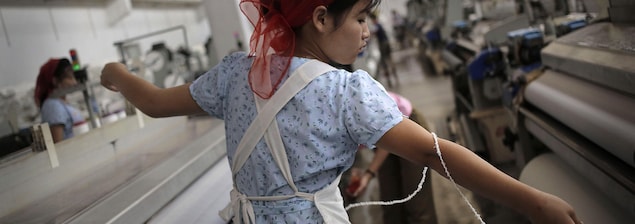 Une femme nord-coréenne tend un fil de laine à l'usine textile Kim Jong Suk Pyongyang. Une femme nord-coréenne tend un fil de laine à l'usine textile Kim Jong Suk Pyongyang.