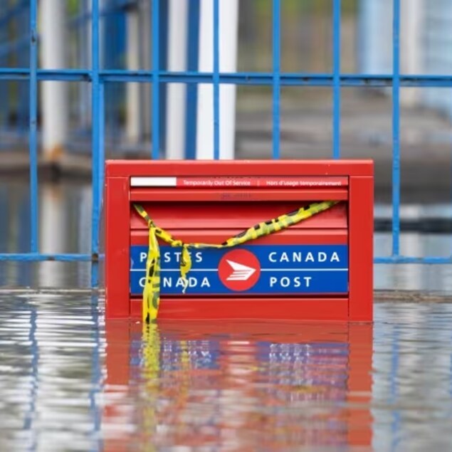 A partially flooded Canada Post mail box during flooding in Gatineau, Que. in the spring of 2023. The Crown corporation lost $290 million in the third quarter of 2023, in part due to the declining demand for letter mail. 