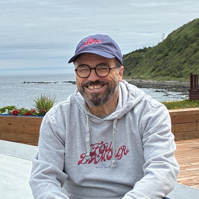 Alan Côté assis en bord de mer
