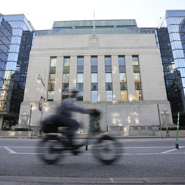 Un cycliste passe devant l'édifice de la Banque du Canada.