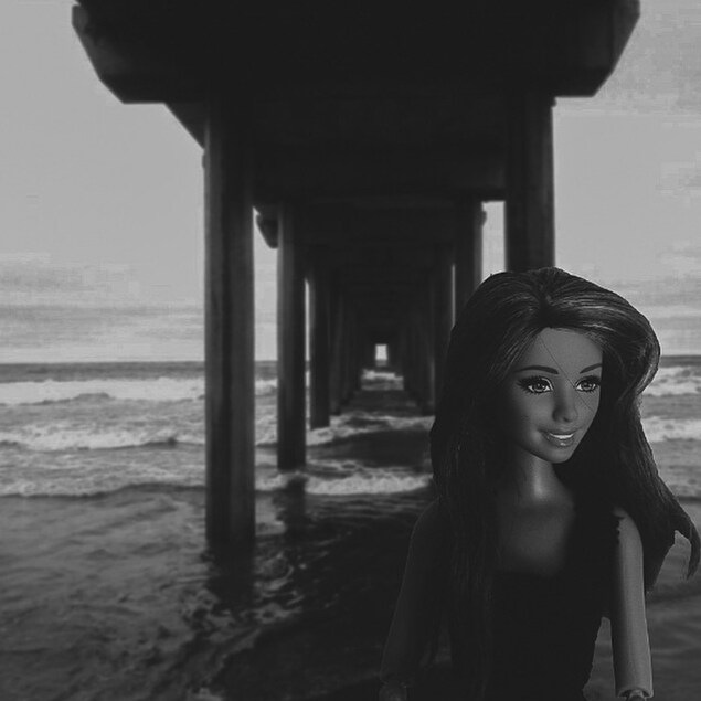 Un montage photo noir et blanc d'une Barbie sous un quai