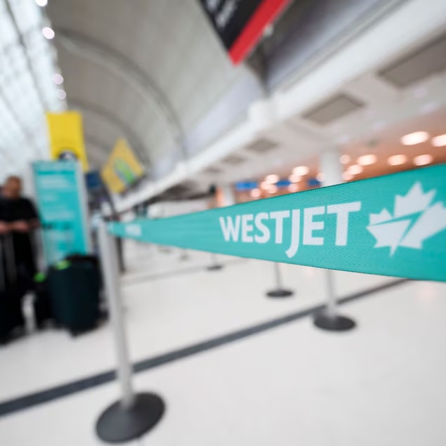 Mga tao sa check-in counter ng WestJet sa isang paliparan.