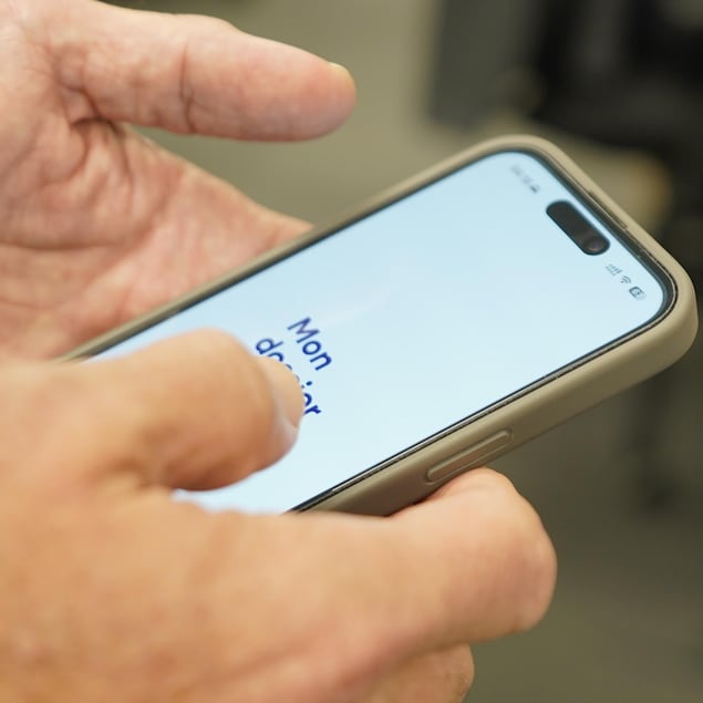 Un téléphone affichant l'application du dossier santé est entre les mains d'une personne. 