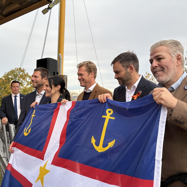Pier-Luc Bujold, Méganne Perry-Mélançon, Alexis Deschênes, Paul Saint-Pierre Plamondon et Pascal Bérubé déploient le drapeau gaspésien. 