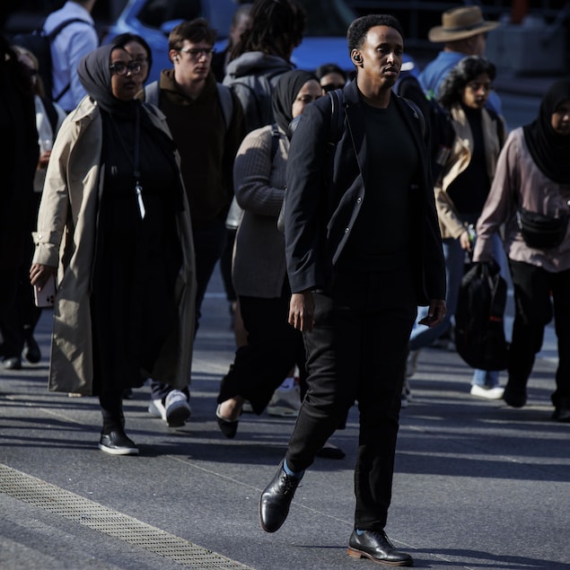 Des Torontois se promènent dans la rue en septembre 2025.