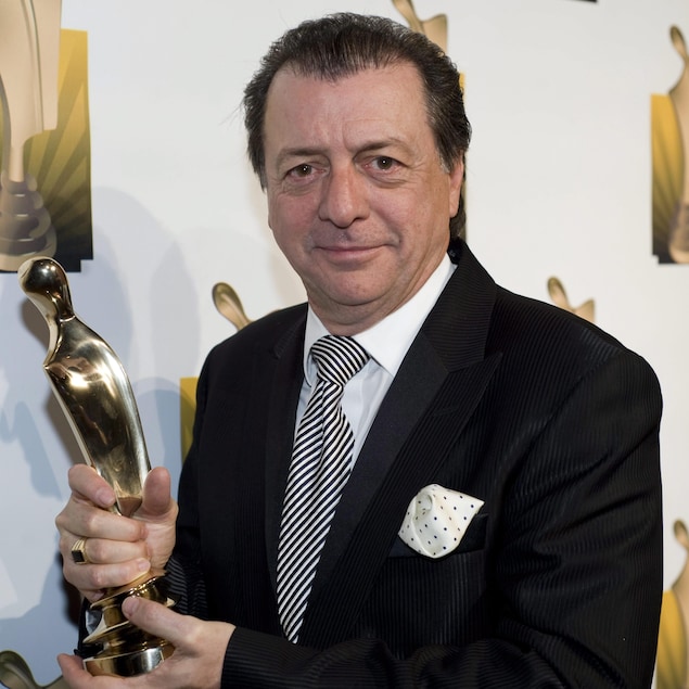 Jean-Luc Mongrain tient son trophée. 