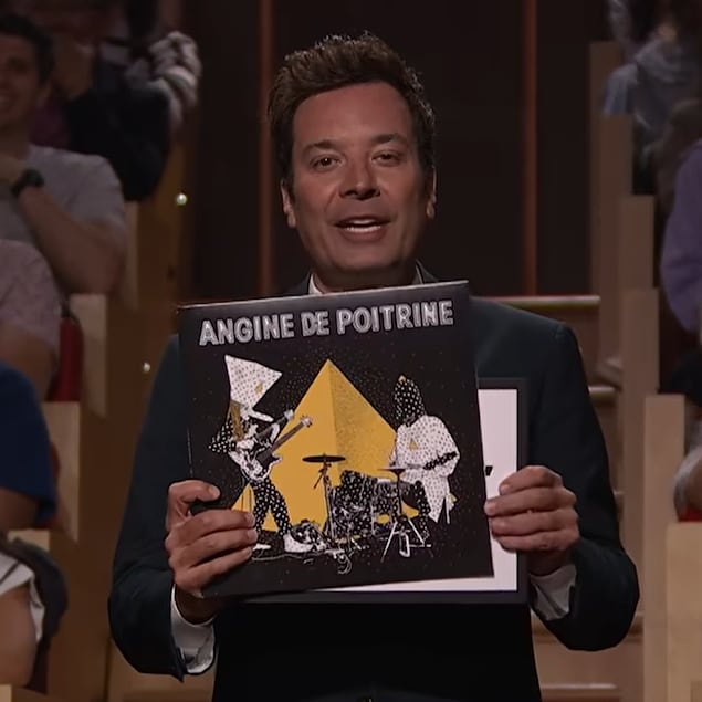 Un homme tient une pochette d'album entre ses mains.