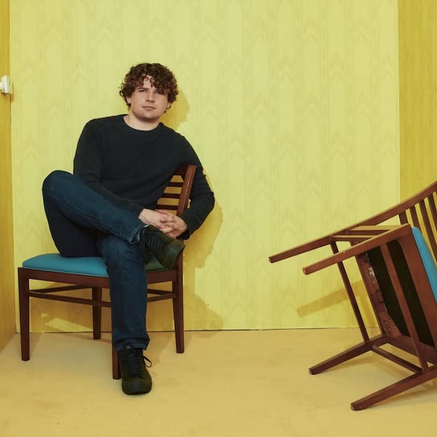 Un jeune homme dans une salle jaune lors d'une entrevue.