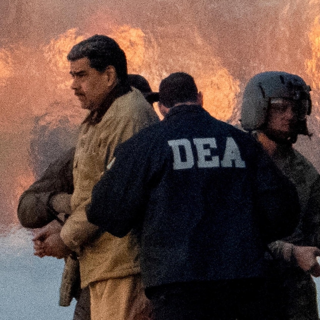 Un homme entouré de membres des forces de l'ordre.  