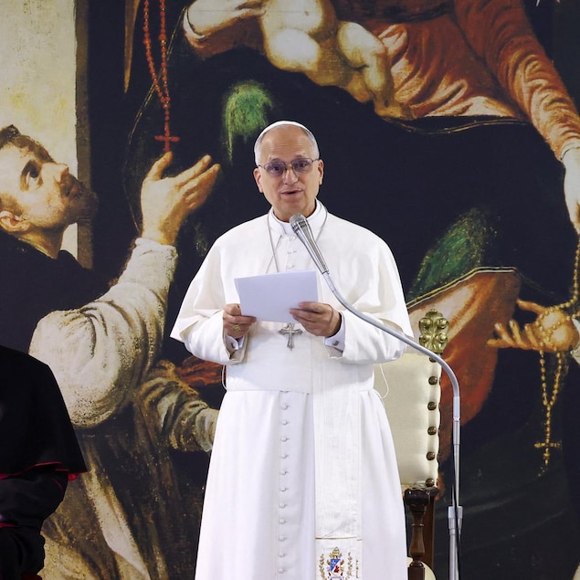 Le pape Léon XIV parle dans un micro dans une église.
