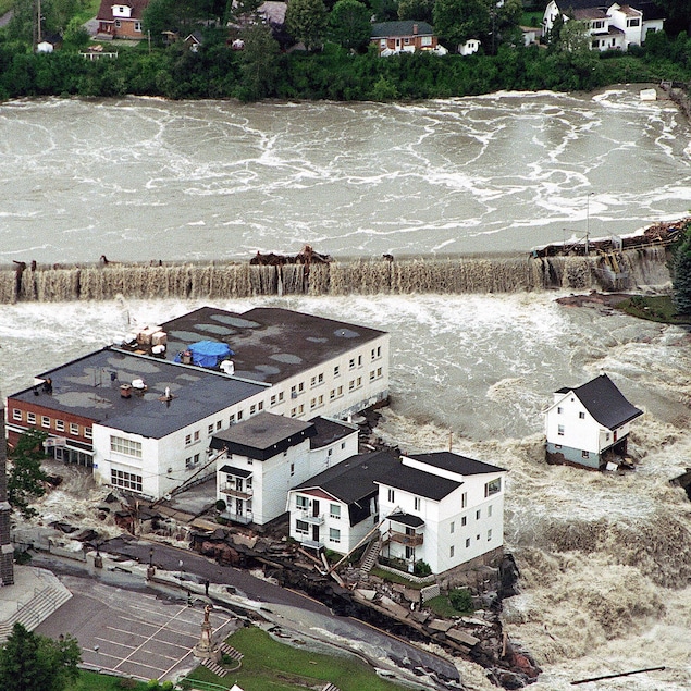 Des bâtiments envahis par des torrents d'eau, à Saguenay en 1996.