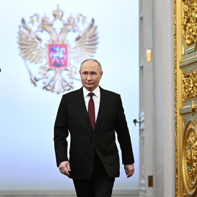 Entouré par deux gardes, Vladimir Poutine marche avant sa cérémonie d'investiture au Kremlin. 
