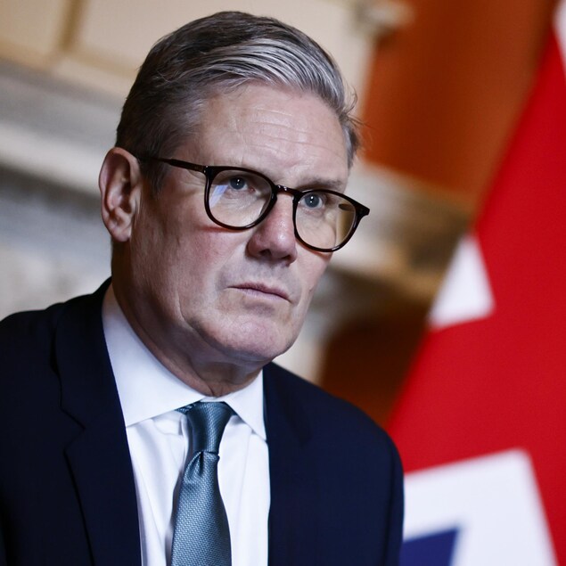 Le premier ministre britannique Keir Starmer photographié devant un manteau de cheminée et un drapeau du Royaume-Uni.