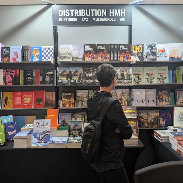 Une personne regarde un étalage au Salon du livre du Saguenay-Lac-Saint-Jean.