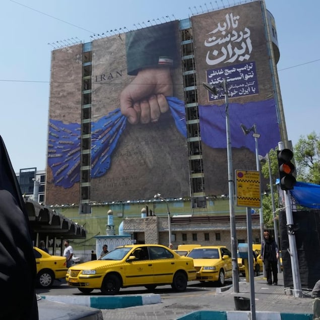 This billboard in Tehran depicts a hand squeezing the Strait of Hormuz. The words in Farsi include, 'In Iran's hands forever," and 'Trump couldn't do a damn thing.'