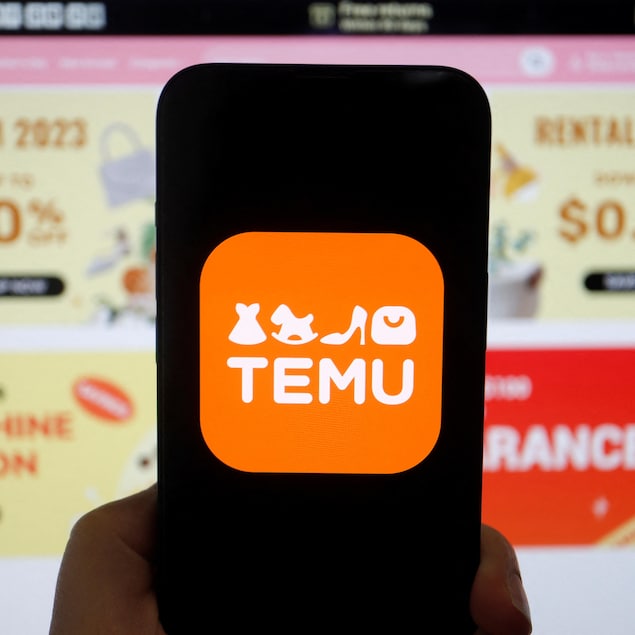 Une main tient un cellulaire affichant l'application Temu.