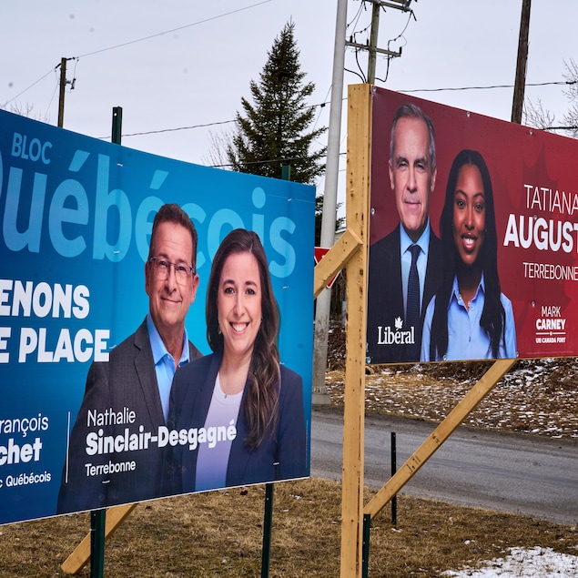 Une affiche du Bloc québécois à côté d'une affiche du Parti libéral du Canada montrant les chefs et leur candidate respective.