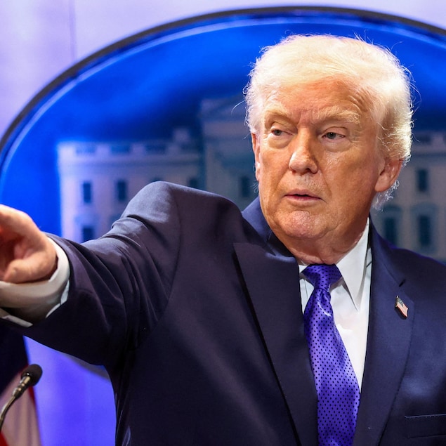 Le président américain Donald Trump pointe à un journaliste. 