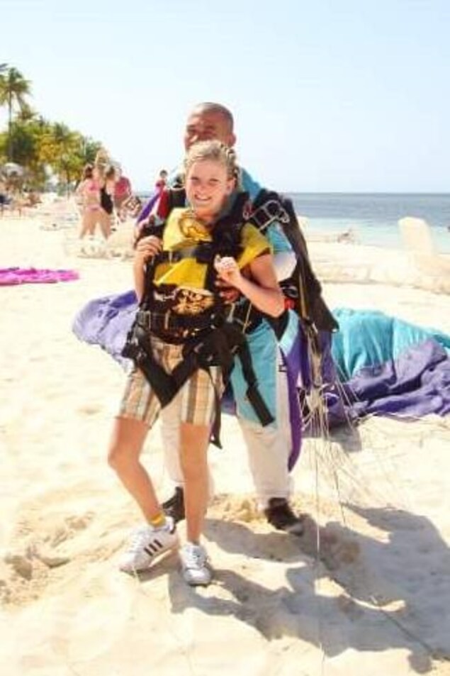 Karine Duval prête à sauter en parachute, sur une plage face à l'océan Karine Duval prête à sauter en parachute, sur une plage face à l'océan