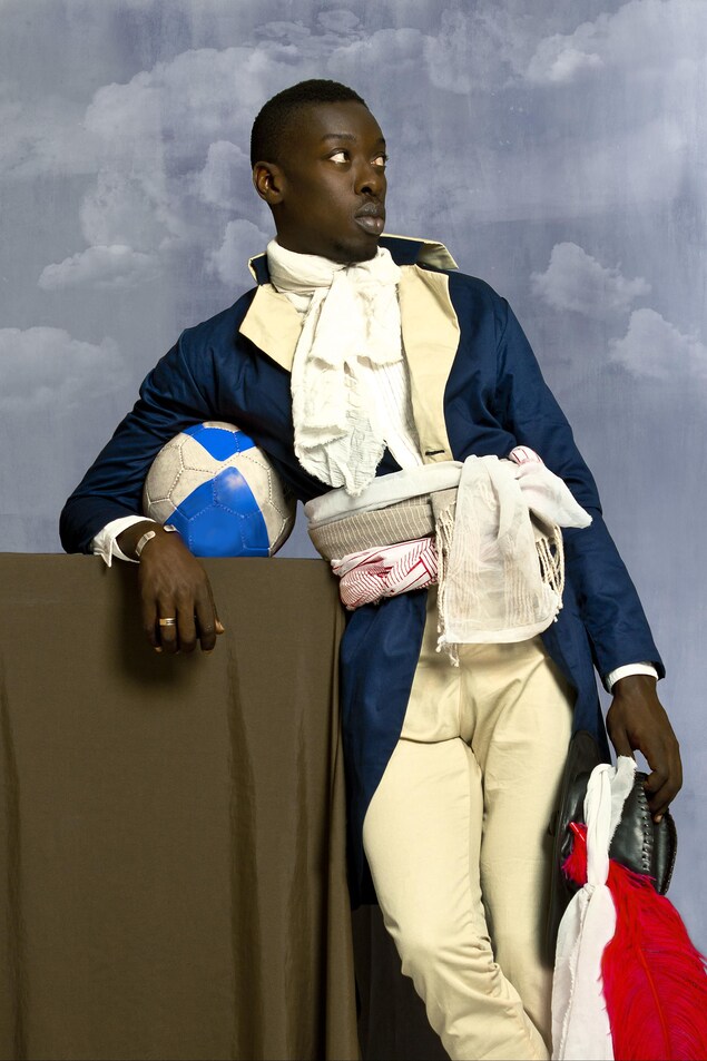 Oeuvre d.Omar Victor Diop montrant un pastiche de Jean-Baptiste Belley avec de l'équipement de sport. Oeuvre d.Omar Victor Diop montrant un pastiche de Jean-Baptiste Belley avec de l'équipement de sport.