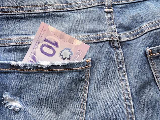 Un billet de 10 dollars canadiens dans la poche arrière d'un jean.