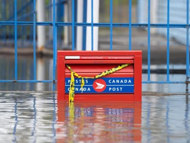 A partially flooded Canada Post mail box during flooding in Gatineau, Que. in the spring of 2023. The Crown corporation lost $290 million in the third quarter of 2023, in part due to the declining demand for letter mail. 