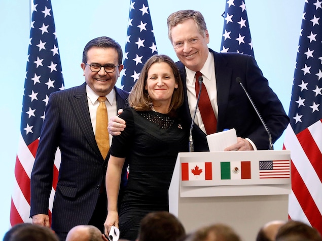 Deux hommes et une femme derrière une tribune, avec les drapeaux canadien, mexicain et américain. Deux hommes et une femme derrière une tribune, avec les drapeaux canadien, mexicain et américain.