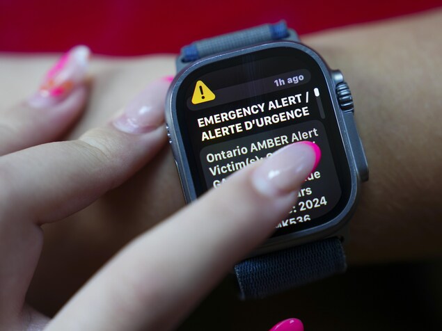 Une femme regarde l'alerte d'urgence sur sa montre.