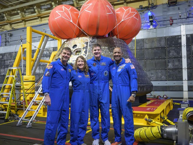 Les astronautes de la NASA Reid Wiseman, commandant (à gauche), Christina Koch, spécialiste de mission ; l'astronaute de l'ASC (Agence spatiale canadienne) Jeremy Hansen, spécialiste de mission ; et l'astronaute de la NASA Victor Glover, pilote d'Artemis II (à droite) sur le pont de chargement de l'USS John P. Mu.
