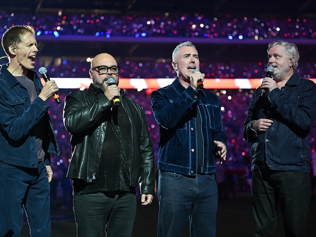 Le groupe Barenaked Ladies, composé de quatre hommes portant des vestes en jeans, interprète l'hymne national canadien avant le match opposant les Lions de Détroit aux Bills de Buffalo au New Highmark Stadium.