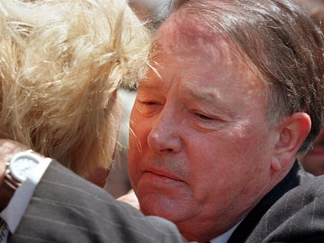 Bernard Landry, le visage attristé, serre quelqu'un dans ses bras. Bernard Landry, le visage attristé, serre quelqu'un dans ses bras.