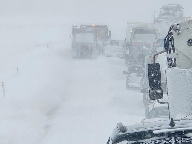 Des camions sur une route enneigée.