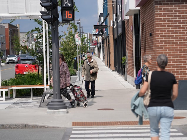 Des passants sur un trottoir de la 3e Avenue, au coeur du centre-ville de Val-d'Or.